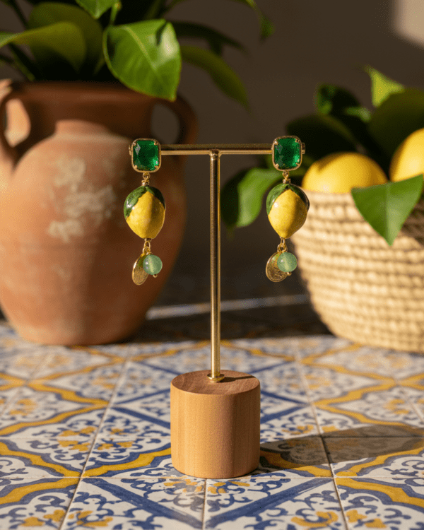 Pendientes Ricco Limón Verde de Haydée en un expositor sobre azulejos sicilianos, con limón de cerámica